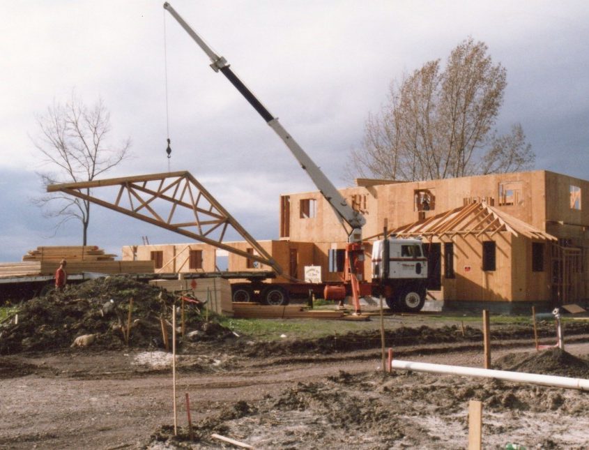 L.E. Baca Construction framing a residential home with crane lifting roof truss into place