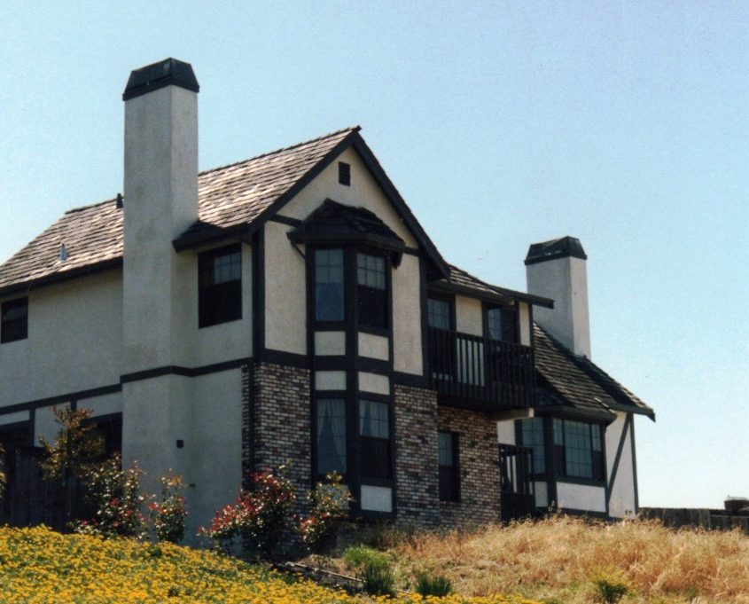 Residential home with mixed exterior materials and a unique roofline